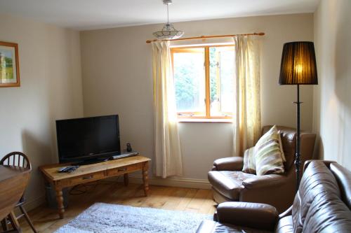 a living room with a couch and a television at Penrith Lodge in Stroud