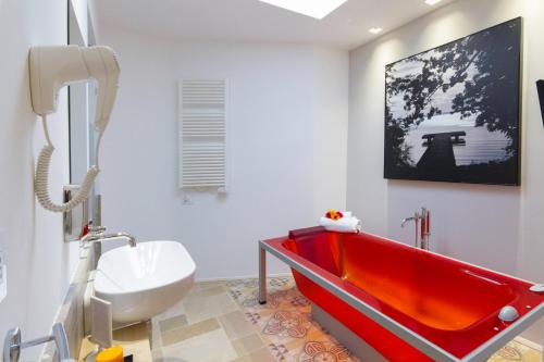 baño con bañera roja y aseo en Santa Marina Bed&Breakfast, en Massafra