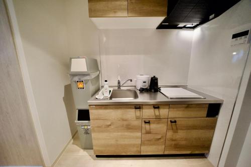 a small kitchen with a sink and a counter at 自由自在OSU 401(NIJI) in Nagoya