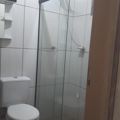 a bathroom with a toilet and a glass shower at Recanto da Lagoa in Passo de Torres
