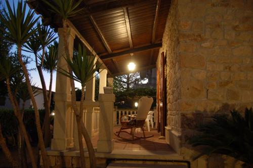 a patio with a wooden roof and a chair on a porch at Casa Romano - Marina di Modica in Marina di Modica