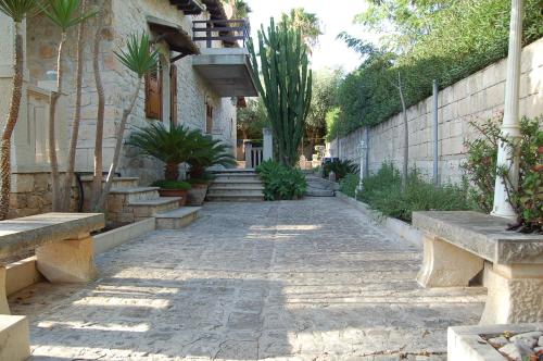 a stone walkway with benches in front of a building at Casa Romano - Marina di Modica in Marina di Modica