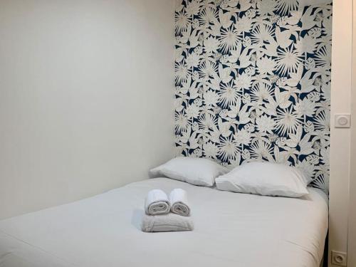 - un lit blanc avec une serviette dans l'établissement Chez Marcel, T2 lumineux, proche gare, à Rennes