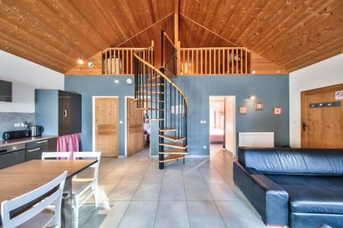 a living room with a wooden ceiling and a staircase at Chalet de charme - Le Martinet in Ney