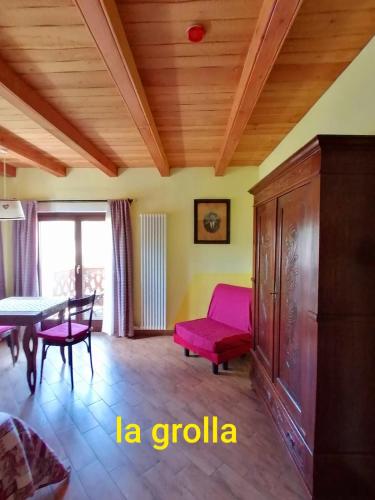 a living room with a red chair and a table at Agriturismo B&B Chèvres à Cheval in Aosta