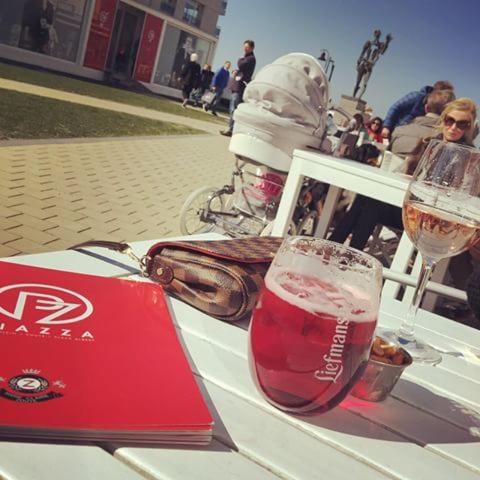 a table with a laptop and a glass of wine at Appartement Sunny home Deluxe in Knokke-Heist