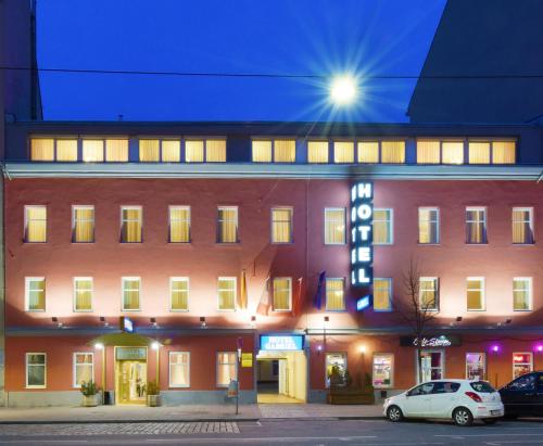 un gran edificio rojo con un cartel delante en Garten- und Kunsthotel Gabriel City, en Viena