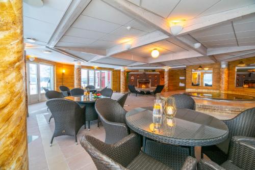 a restaurant with tables and chairs in a room at Grand Arctic Resort in Överkalix