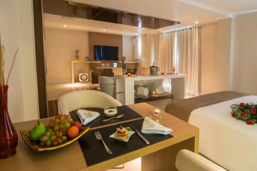 una habitación de hotel con una mesa con un bol de fruta en Modevie Boutique Hotel en Gramado