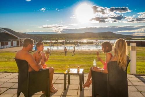 a family sitting on a patio watching a game of baseball at Grand Arctic Resort in Överkalix