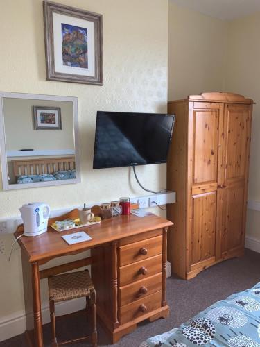 una camera da letto con scrivania in legno e cassettiera di Brafferton Guest House a Hartlepool