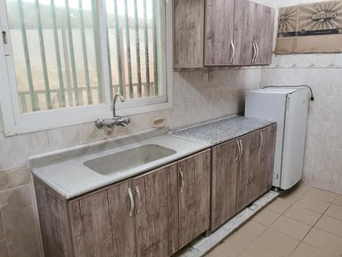 a kitchen with a sink and a refrigerator at شقق عائلية مع انترنت مجاني in Al Ahsa