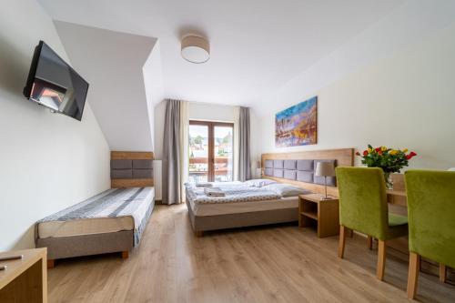 シュクラルスカ・ポレンバにあるEskapadaのベッド、テーブル、椅子が備わるホテルルームです。
