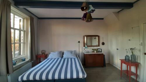 a bedroom with a bed with a blue and white stripes at B&b Hoogholtje in Onderdendam