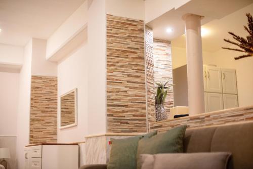 a living room with a couch and a brick wall at Mediterranean in Preveza