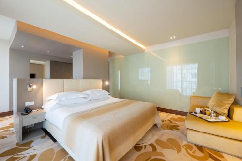 um quarto com uma cama grande e uma cadeira em Smy Lisboa em Lisboa