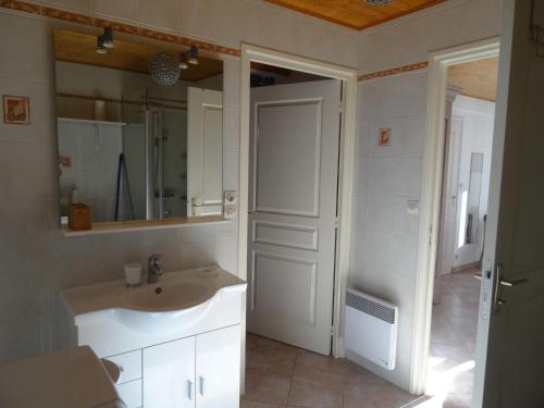 ein Bad mit einem Waschbecken und einem Spiegel in der Unterkunft Gite 3 étoiles les Nougers in La Tremblade