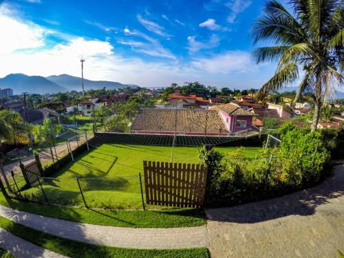 a yard with a grass field and a house at Chalés Mirante da Lagoinha in Ubatuba