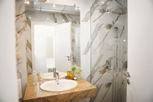 a bathroom with a sink and a mirror at Plovdiv City Center Hotel in Plovdiv