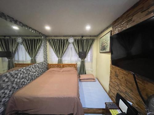 a bedroom with a bed and a flat screen tv at Cozy Studio Hotel-like Condominium at Megatower Residences in Baguio