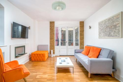 uma sala de estar com um sofá e uma televisão em TruStay Apartments London Bridge em Londres
