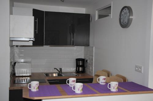 a kitchen with a counter top with mugs on it at Magicappart in Magny-le-Hongre