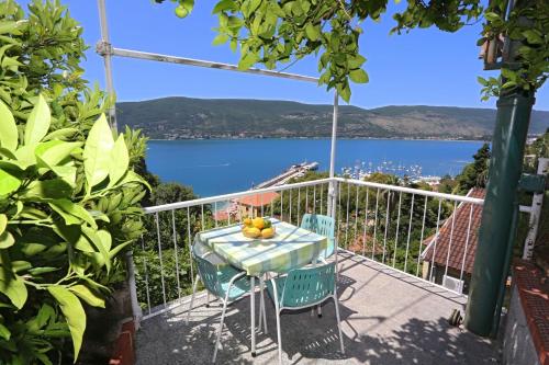 uma mesa e cadeiras numa varanda com vista para a água em Studio Stari Grad em Herceg Novi