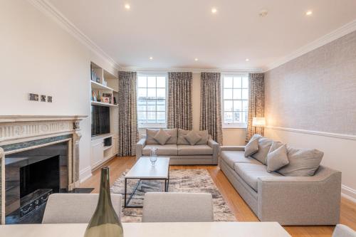 a living room with two couches and a fireplace at 20 Hertford Street - Mayfair Apartments in London