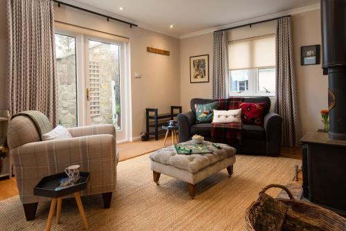 a living room with a couch and a chair at Bastle Retreats Farm Cottage in Duns