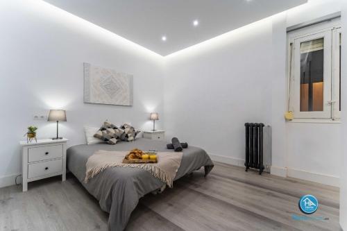 a white bedroom with a bed and a window at Boutique Madrid Center Apartment in Madrid