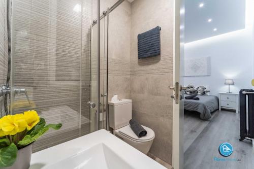 a bathroom with a toilet and a glass shower at Boutique Madrid Center Apartment in Madrid