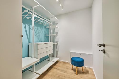 a room with a blue chair and a closet at Hafensuite Pura Vida in Olpenitz