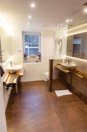 a bathroom with two sinks and a mirror at Ferienwohnung Rotbuche in Tannenberg
