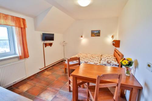 a living room with a table and a bed at Aparthotel Teddy Kvilda in Kvilda