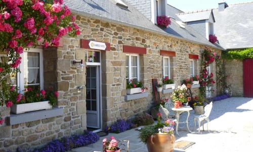 a stone building with flowers on the side of it at Lanévry, Gradlon in Kerlaz