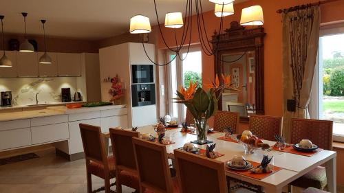 a dining room with a table and chairs and a kitchen at Lanévry, Gradlon in Kerlaz