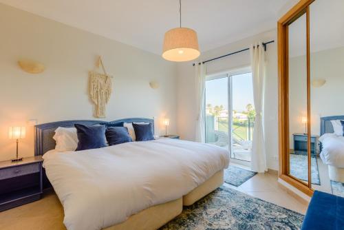 a bedroom with a large bed and a large window at Casa Lomy - Boavista Resort and Spa in Lagos