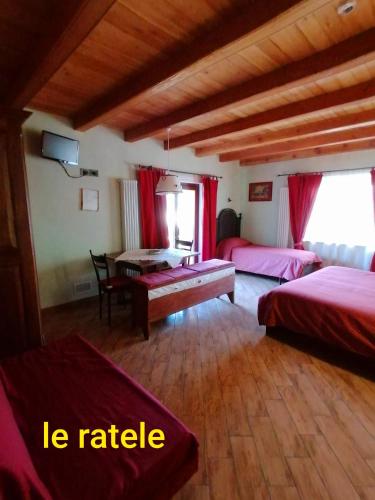 a bedroom with two beds and a table in it at Agriturismo B&B Chèvres à Cheval in Aosta