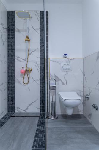 a bathroom with a shower with a toilet and a sink at Royal Residence Deluxe Apartments in Bihać