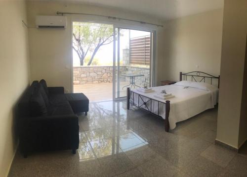 - une chambre avec un lit, un canapé et une chaise dans l'établissement Nereids Apartments-Thetis, à Petalidhion