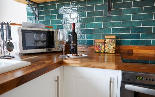 a kitchen with a counter with a microwave and wine glasses at Host & Stay - Marine Sands in Scarborough