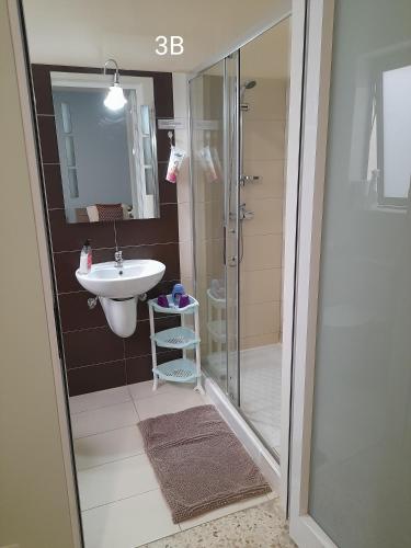 un baño con ducha y lavabo en Seabreeze Holiday Guestrooms, en St Paul's Bay