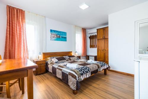 a bedroom with a bed and a desk in it at Casa Luca 2 in Vama Veche