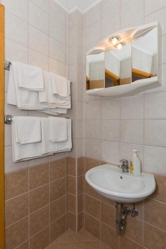 a bathroom with a sink and a mirror and towels at Villa Dubravka in Mlini