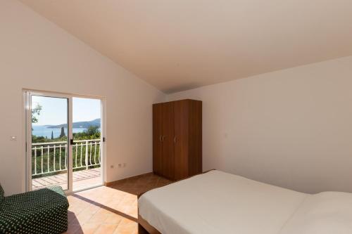 a bedroom with a bed and a balcony at Villa Dubravka in Mlini