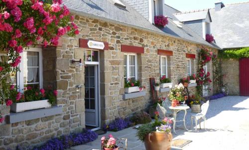 a stone building with flowers on the side of it at Lanévry, Korrigan in Kerlaz