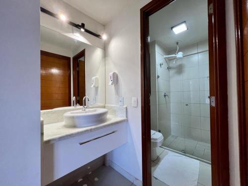 y baño blanco con lavabo y ducha. en Elegance Hotel Natal Beira Mar en Natal