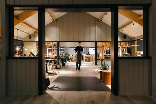 a man walking through a room with windows at Hotel Katla by Keahotels in Vík
