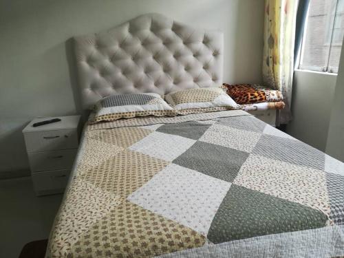 een slaapkamer met een groot bed en een geruite deken bij Studio entero cerca al Palacio Gobierno in Lima