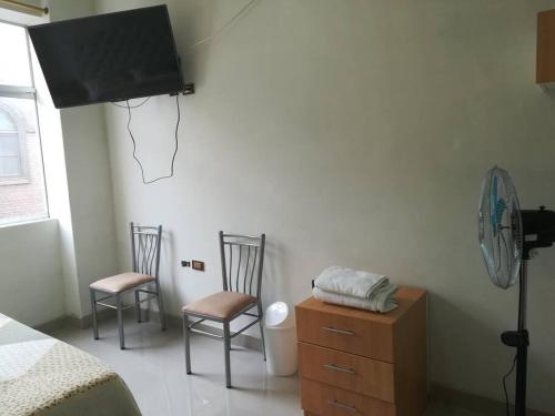 een slaapkamer met 2 stoelen en een basketbalring aan de muur bij Studio entero cerca al Palacio Gobierno in Lima